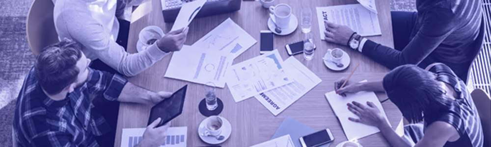 People working in a group with documents scattered on table